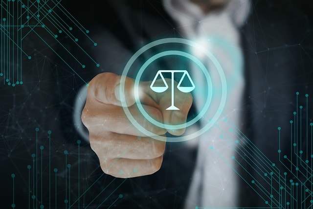 A businessman points at a glowing digital icon of justice scales, symbolizing legal technology or compliance, with a futuristic network background.